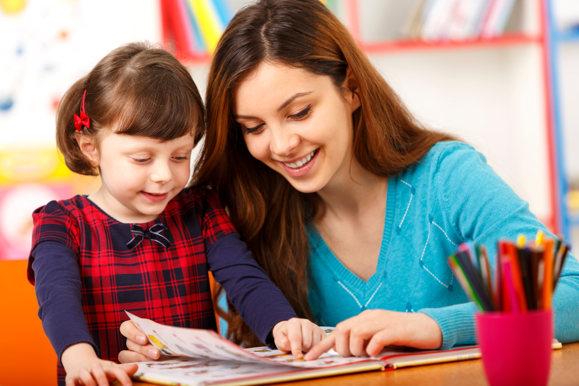 Child reading with a preschool teacher