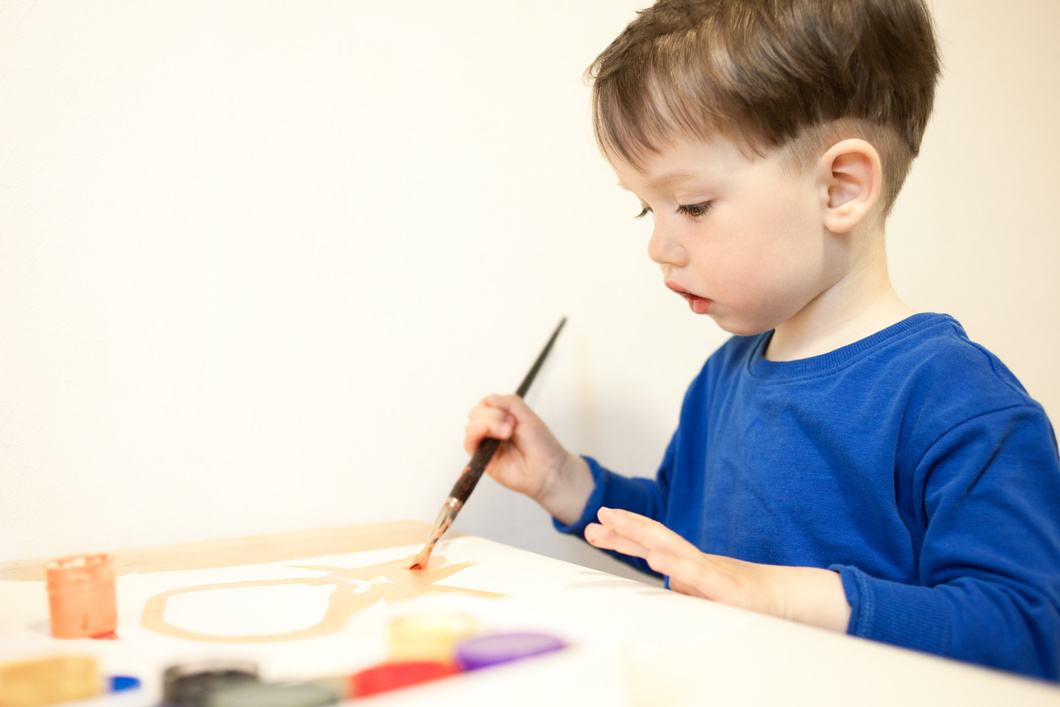 3 year old baby boy draws paints
